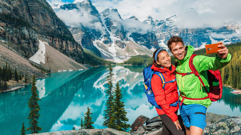 Couple taking a picture surrounded by mountains