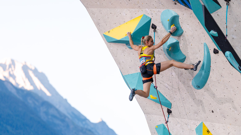 Woman maneuvering on climbing wall