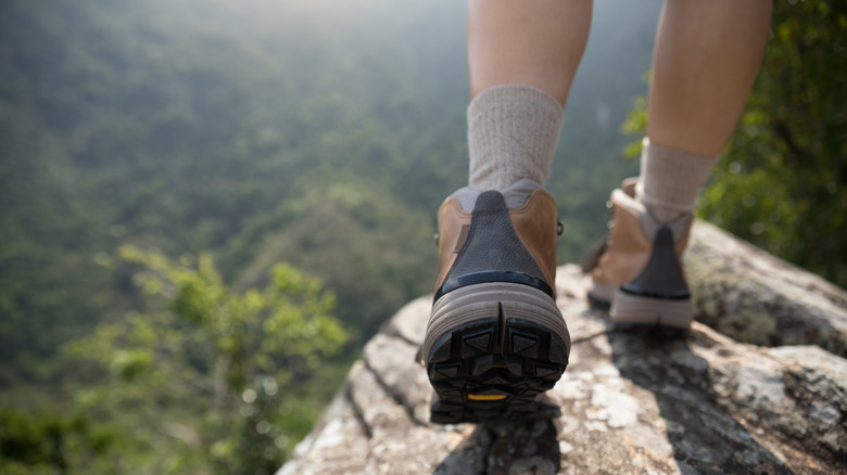 Hiker with socks and boots on a precipice