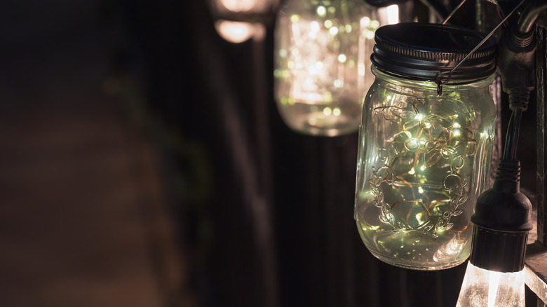 hanging mason jar lights outside in the dark.