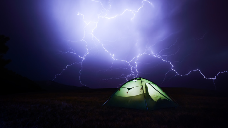 Green tent with lightning in the sky