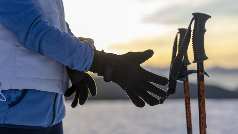 A woman reaches for ski poles