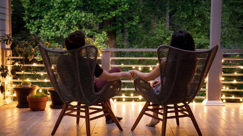 Couple sitting on back porch with yellow lighting