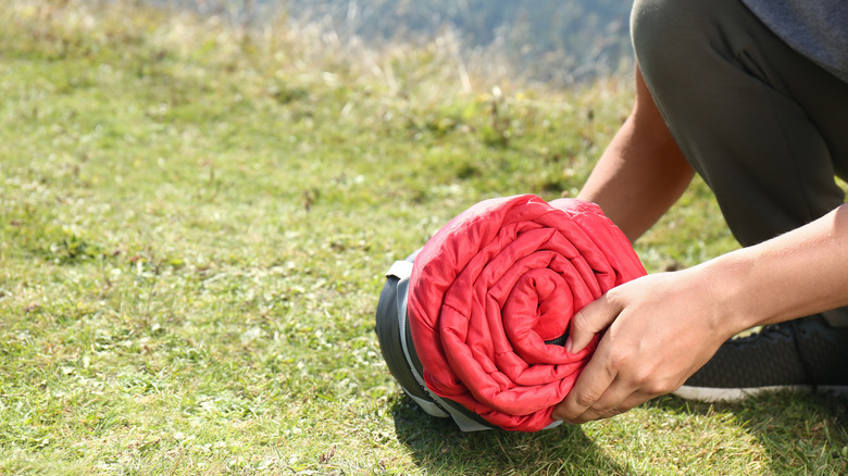 Person putting a sleeping bag into a stuff sack