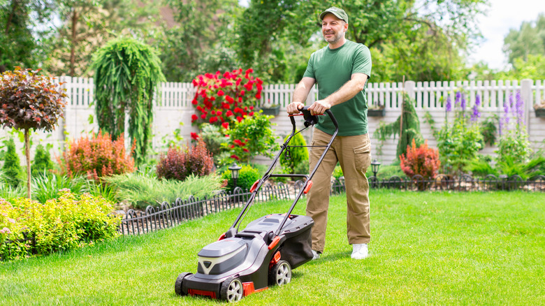 A man happily mowing a lawn