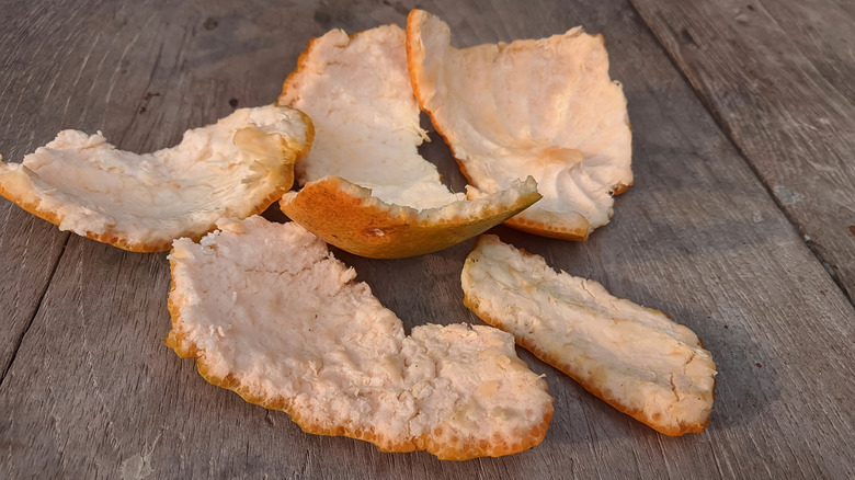 Rinds of a grapefruit on a wooden table outside