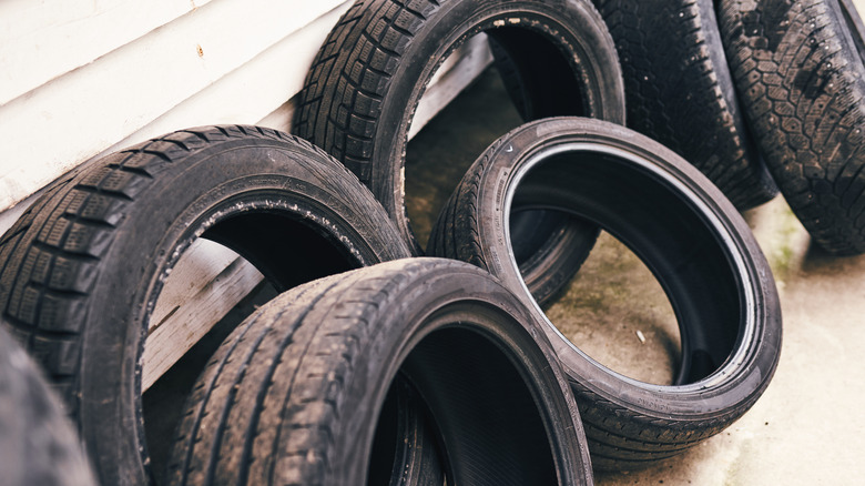Old tires leaning against a house's siding