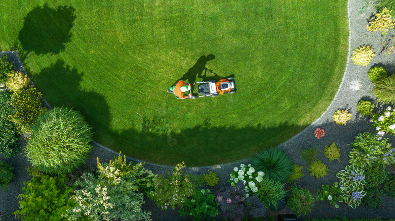overhead view of man mowing home lawn