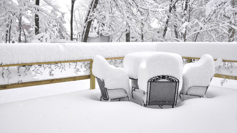 Deck and outdoor furniture covered with a foot or two of snow