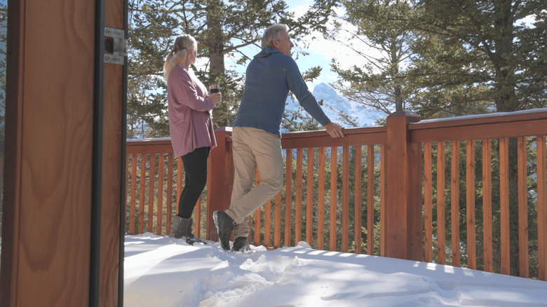 Couple standing on a deck with light snow