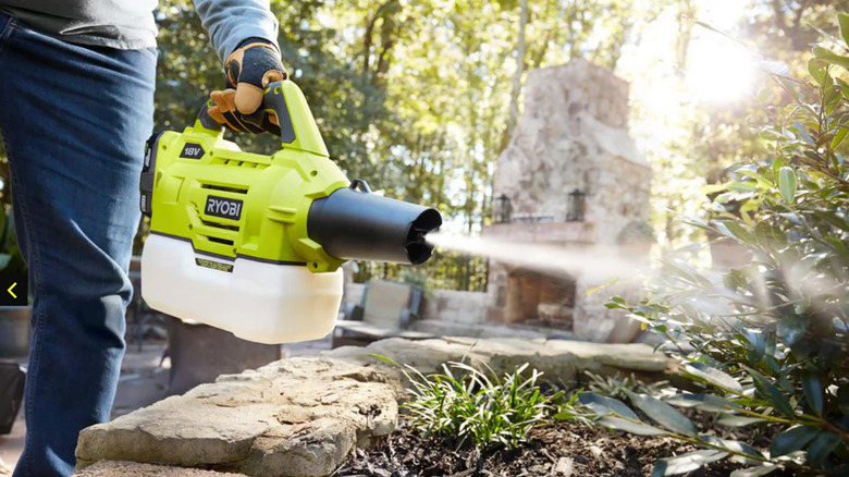 Ryobi One+ cordless mister being used to spray a shrub