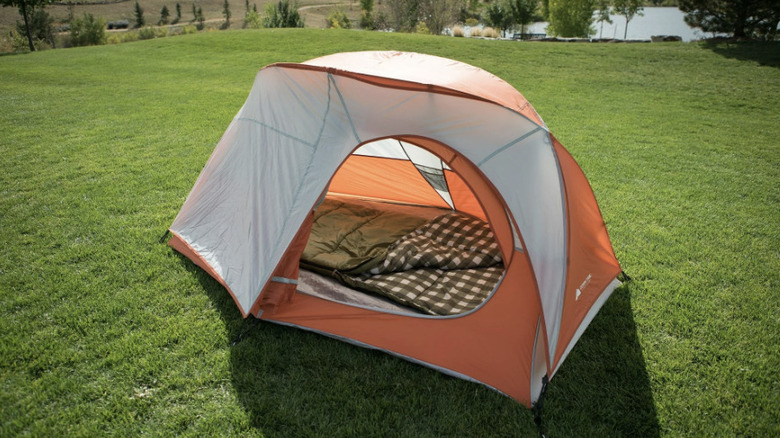 Ozark Trail single person tent on hill with lake in background