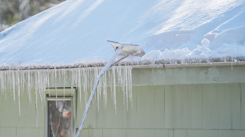 Using a roof rake on a snow-covered roof