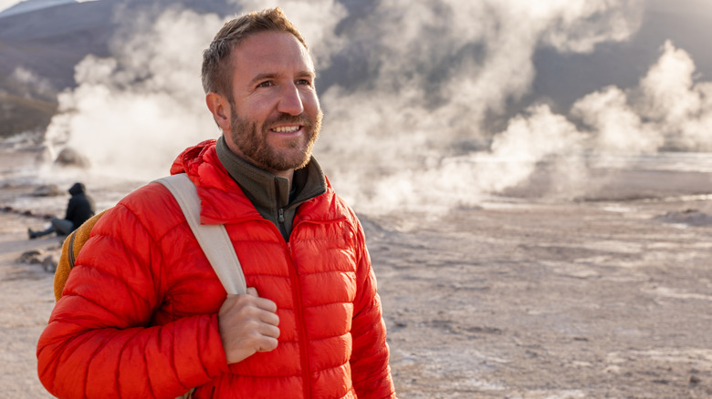 Hiker with puffer jacket near hot springs