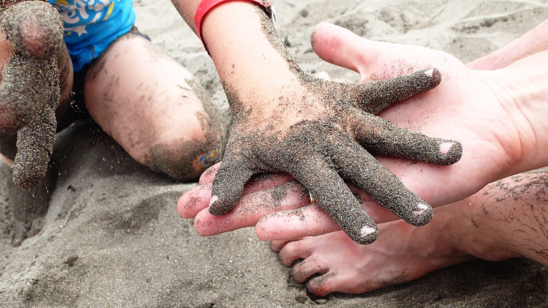 Sand stuck on child's hand