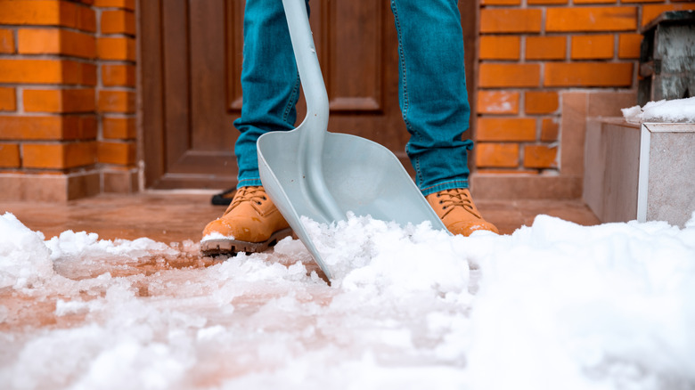 Close-up of snow shoveling in front of home