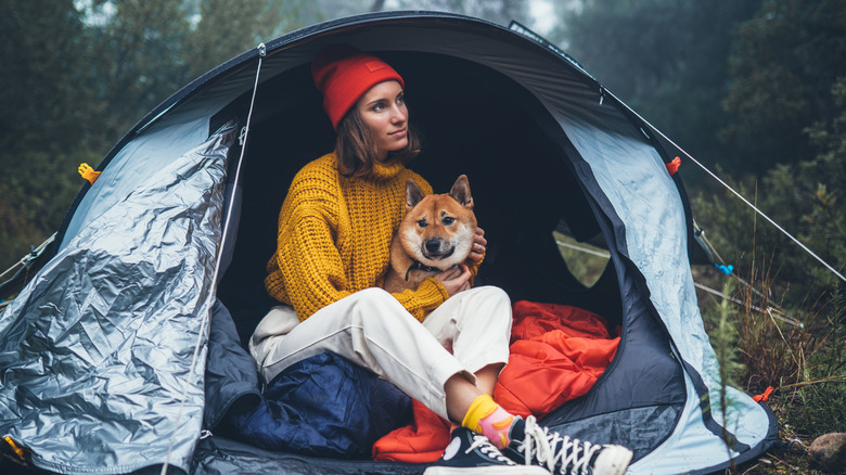 Camper with dog inside tent