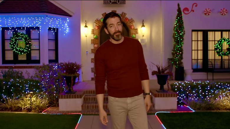 Drew Scott in front of his festive home