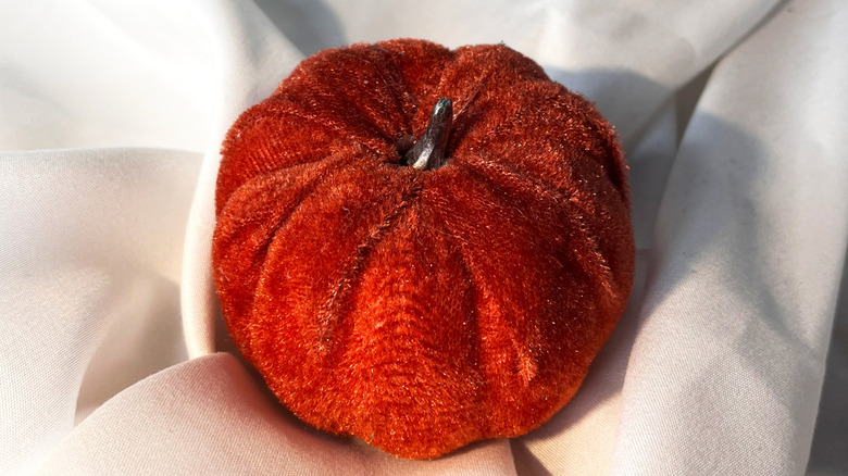 Red fabric pumpkin on a white cloth
