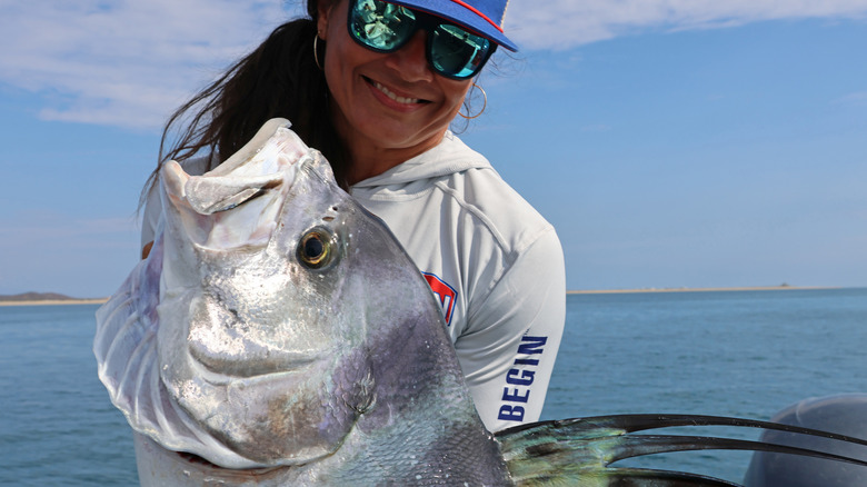 Woman displays a roosterfish in the Sea of Cortez