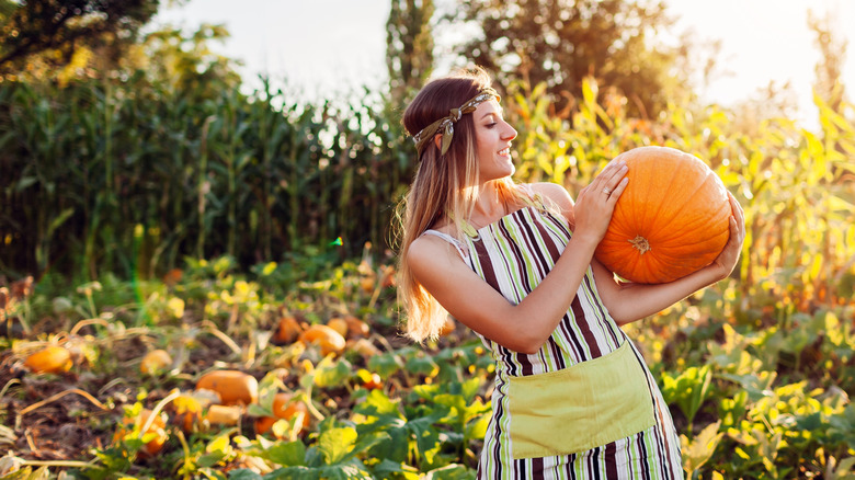Woman inspecting a pumpkin from her garden