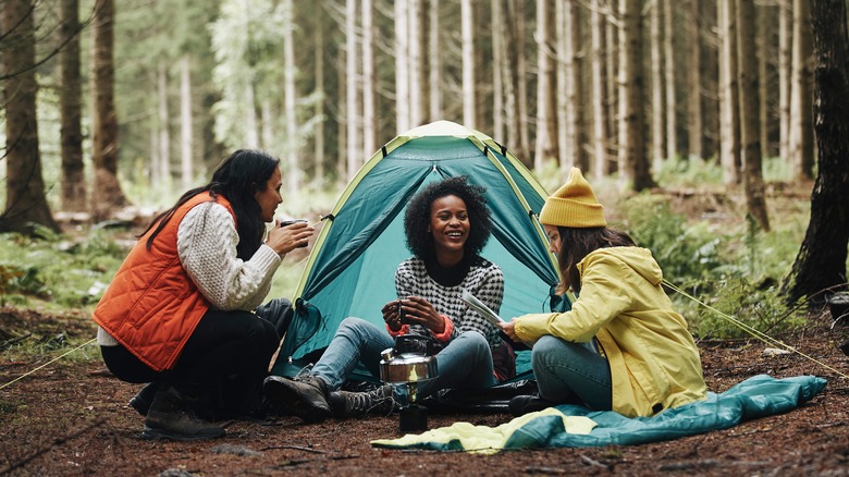 three women camping in a forest