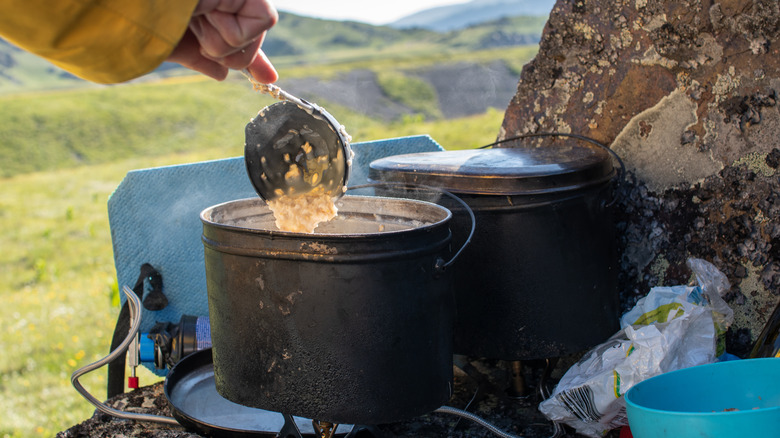A camper making a pot of oatmeal in the wilderness