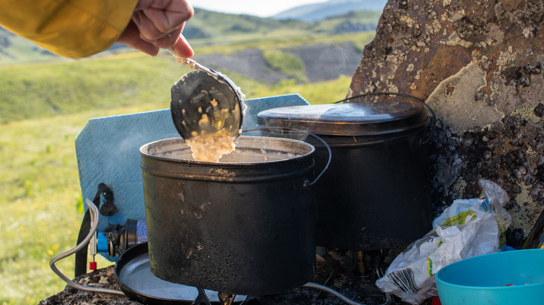 A camper making a pot of oatmeal in the wilderness
