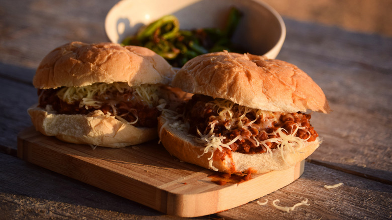 A pair of sloppy joes on a picnic table