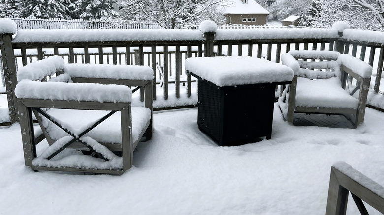 snow-covered furniture on a deck