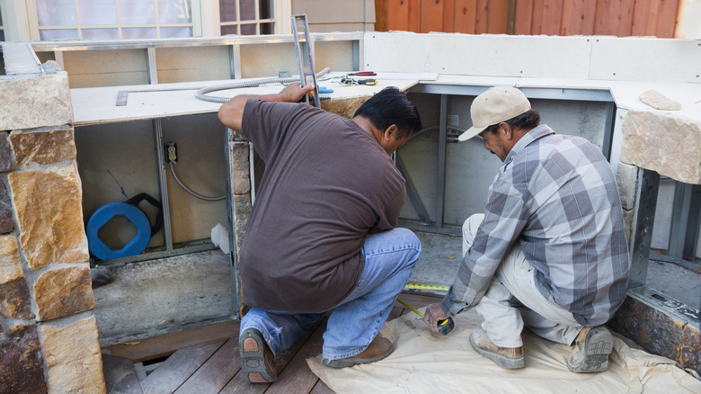 Two mean building an outdoor kitchen