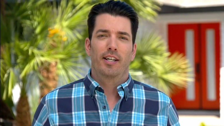 Drew Scott in front of his colorful house