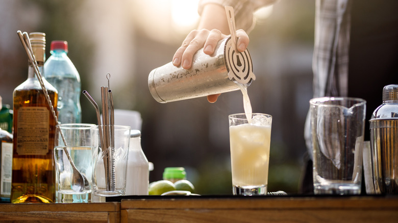 A man preparing cocktails on an outdoor bar