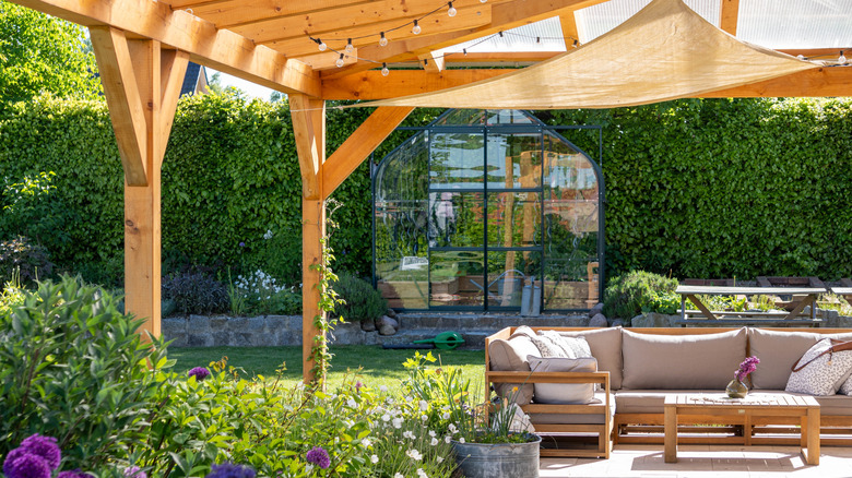 An outdoor seating area sheltered with a pergola and shade
