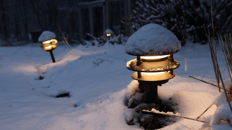 Outdoor path lights glowing in the snow