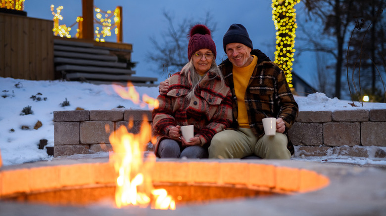 A couple enjoying hot cocoa by the fire pit