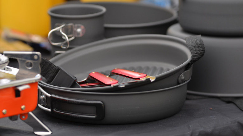 An abundance of camping pans on a table