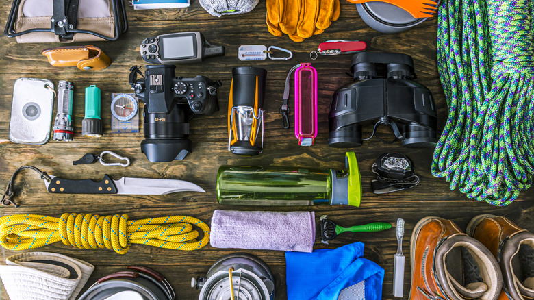 A top-down view of a table laden with camping gear and accessories