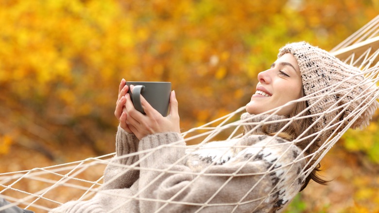 camper in a hammock surrounded by fall foliage