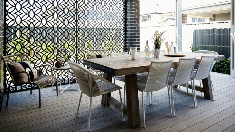 backyard patio area with outdoor dining table and privacy screen