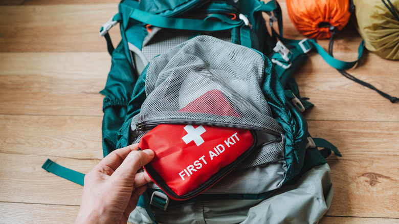 Person taking first aid kit out of backpack