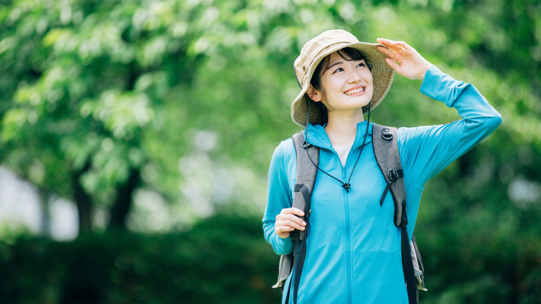 Woman hiking with sun protective clothing and hat