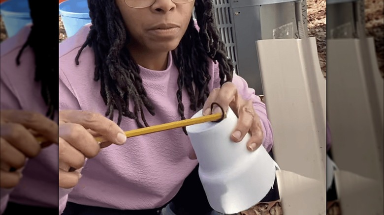 Person demonstrating a DIY foam cup faucet cover