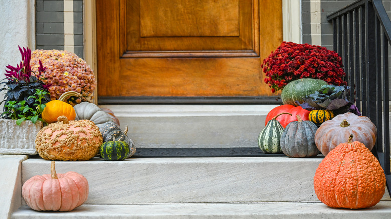 pumpkins on steps leading to a door outside