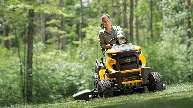 A woman riding on a Cub Cadet tractor