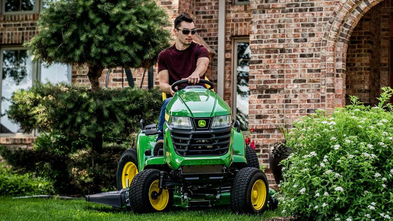 A man on a John Deere tractor mower