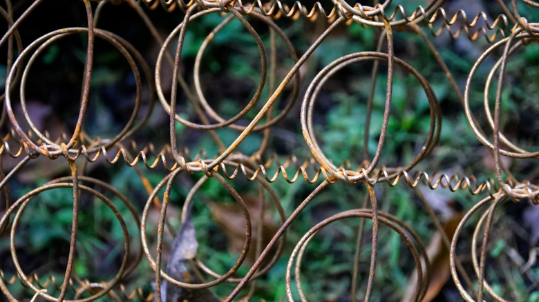 Metal interior of a box spring mattress propped up outside