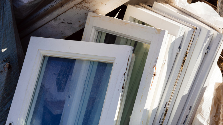 A pile of old white window frames with windows