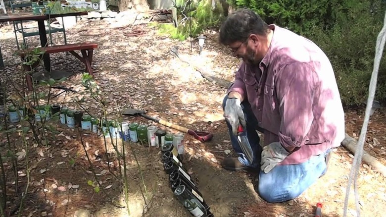 Gardener explaining how to do wine bottle garden edging