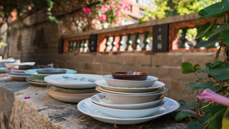 Dishes on display beside pink flowers